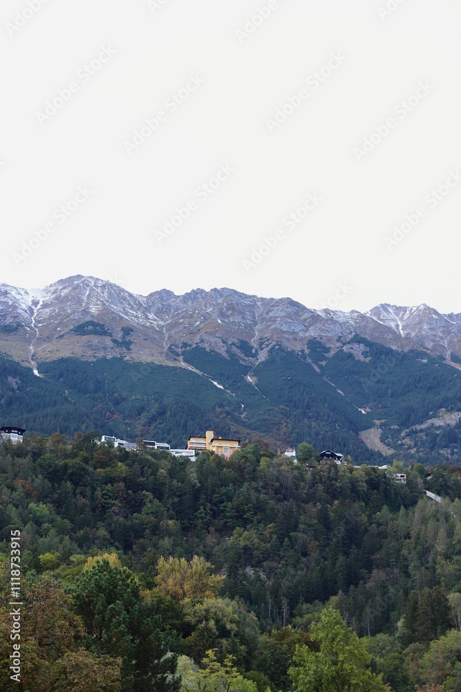 Scenic View of Alpine Landscape and Mountains with Village on Hillside in Innsbruck, Austria Scenic View of Alpine Landscape and Mountains with Village on Hillside in Innsbruck, Austria