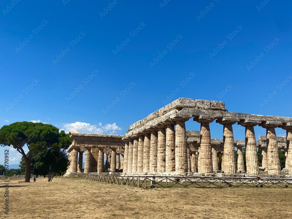 Ancient Greek Temple Ruins in Paestum, Italy, Under a Clear Blue Sky Ancient Greek Temple Ruins in Paestum, Italy, Under a Clear Blue Sky