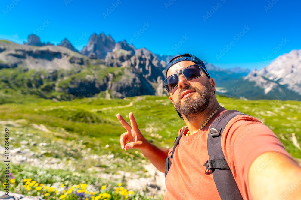 Three Peaks of Lavaredo, Tourist taking selfie while hiking in the dolomites with tre cime di lavaredo in background Three Peaks of Lavaredo, Tourist taking selfie while hiking in the dolomites with tre cime di lavaredo in background