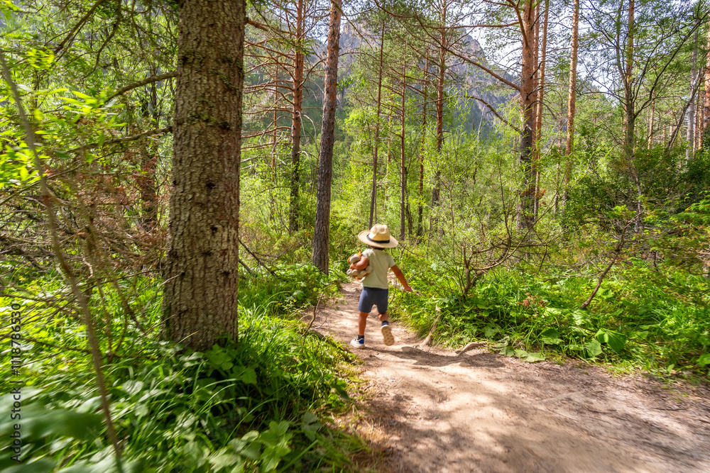 Child running on a path in a sunny forest Child running on a path in a sunny forest