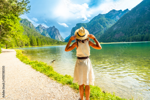 Tourist enjoying breathtaking view of lake dobbiaco in the dolomites photo