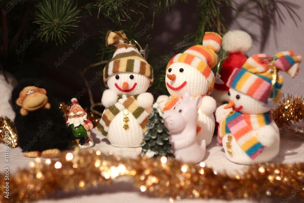Fototapeta premium Snowmen in hats and scarves, against the background of a Christmas tree. Set of figures, snowmen smiling, carrot nose, for decor and interior decoration for the New Year and Christmas
