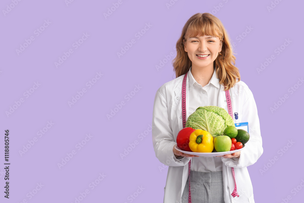 Young happy female nutritionist with fresh vegetables and measuring tape on purple background Young happy female nutritionist with fresh vegetables and measuring tape on purple background