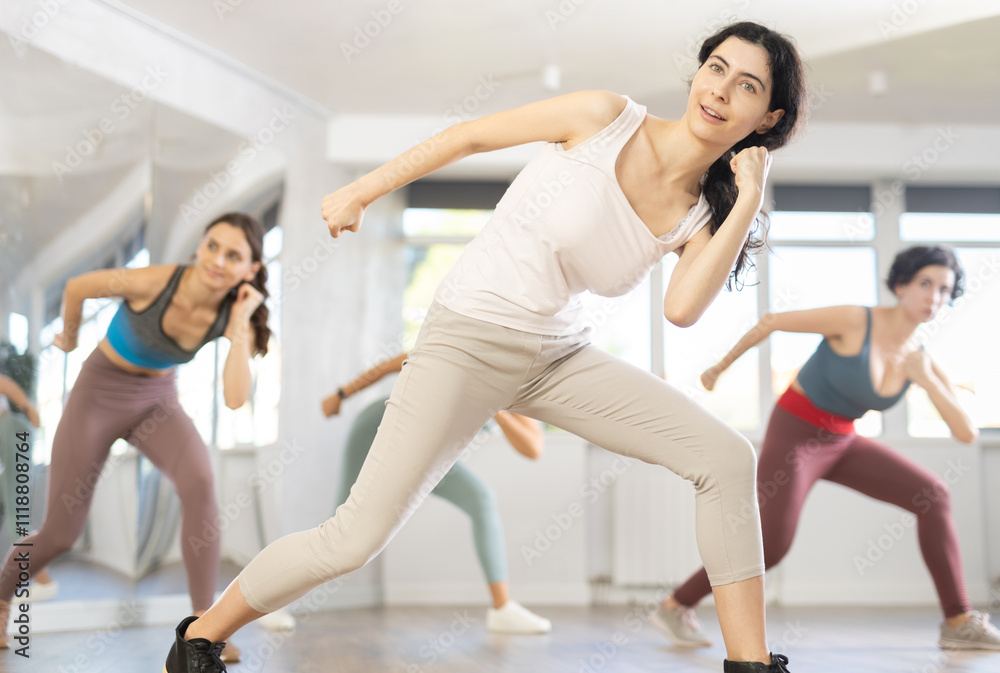 Obraz premium Group of women learning modern dance movements at class together
