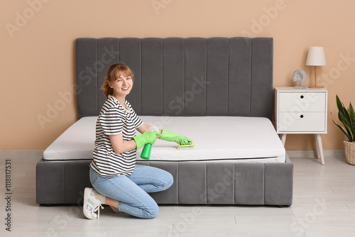 Young woman cleaning mattre...