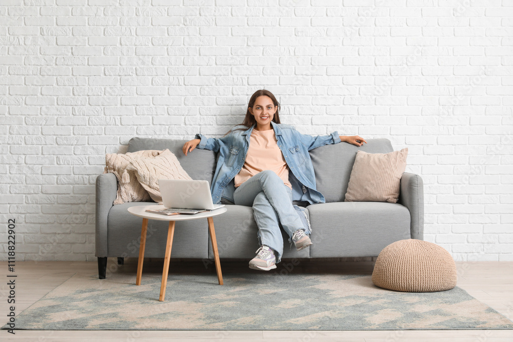 Young beautiful woman resting on grey sofa at home Young beautiful woman resting on grey sofa at home