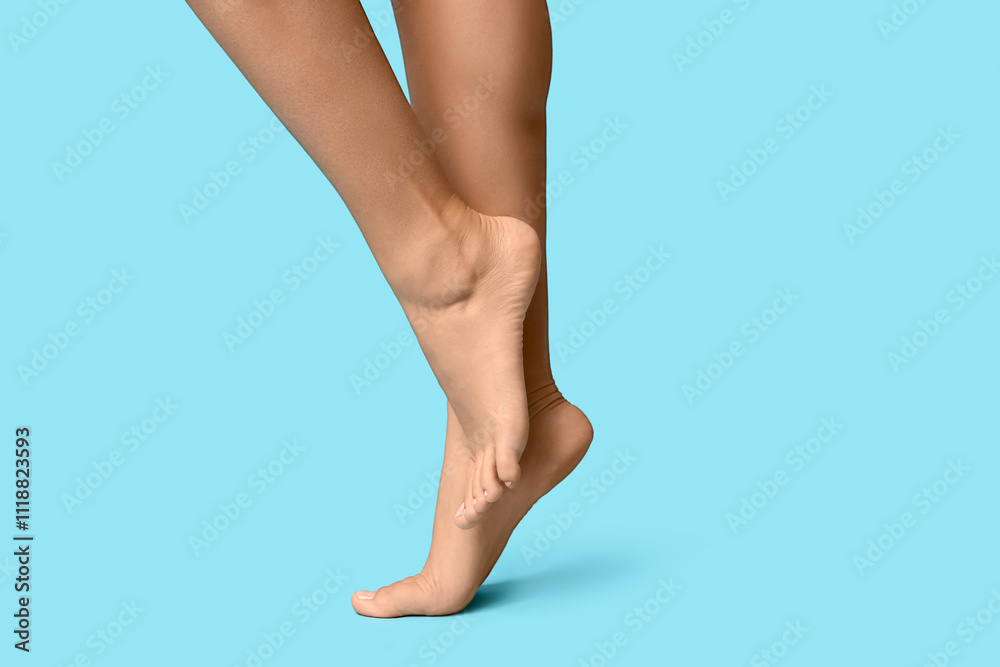 Legs of young woman with pedicure on blue background Legs of young woman with pedicure on blue background