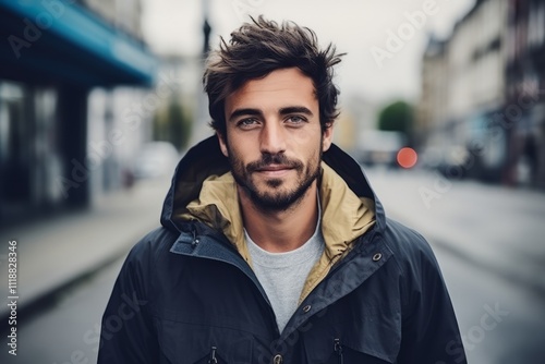 Portrait of a handsome young man in the city, wearing a jacket.