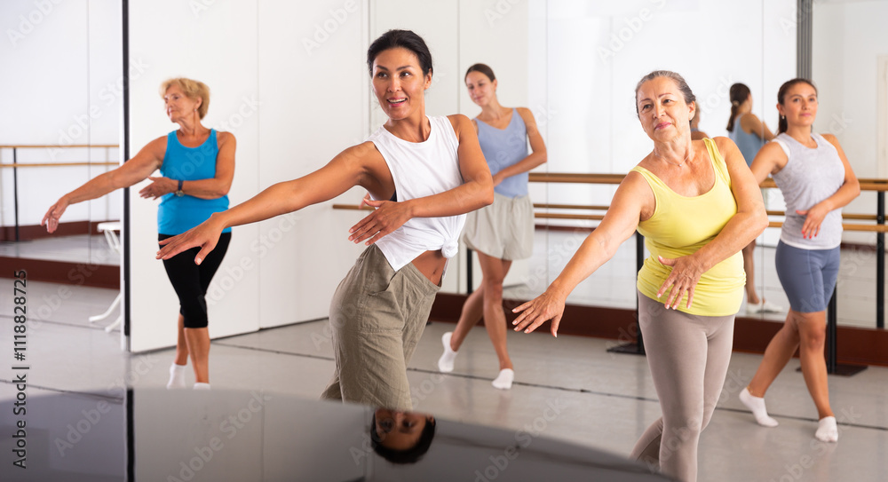 Group of various aged women dancing modern dance in studio. Group of various aged women dancing modern dance in studio.