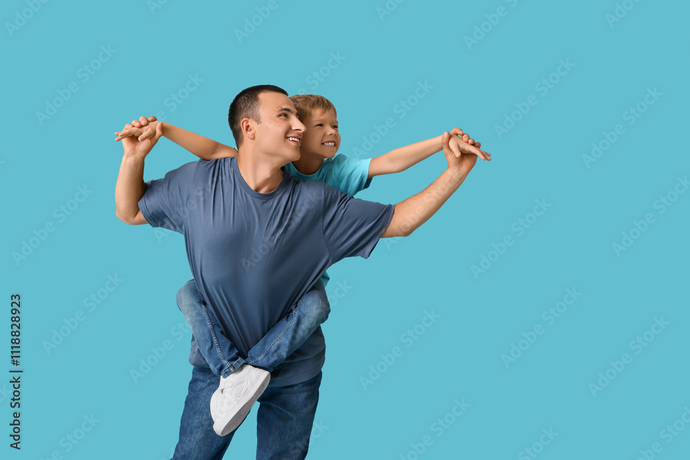 Happy father playing with his little son on blue background