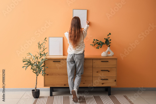 Young woman hanging blank f...