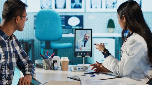 Indian physician entering a video call with expert to discuss diagnostic report, asking the specialist for a second opinion on remote videoconference. Doctors meeting online for telehealth. Camera A. photo