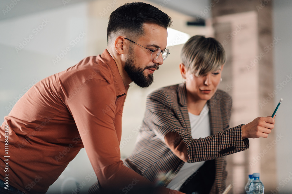 Obraz premium Business people collaborating and pointing at screen in office meeting