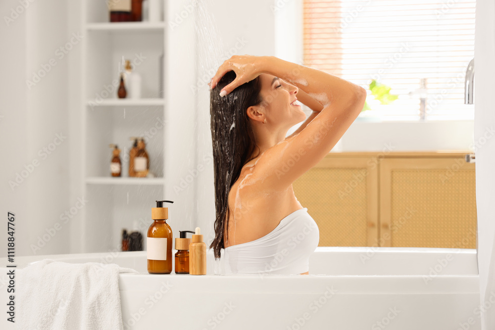 Beautiful young happy woman taking bath with cosmetic products and soap foam at home Beautiful young happy woman taking bath with cosmetic products and soap foam at home