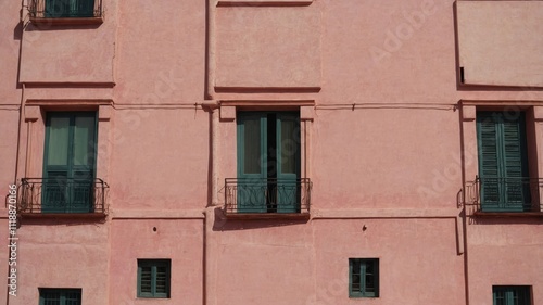 Pink plaster facade with small urban windows