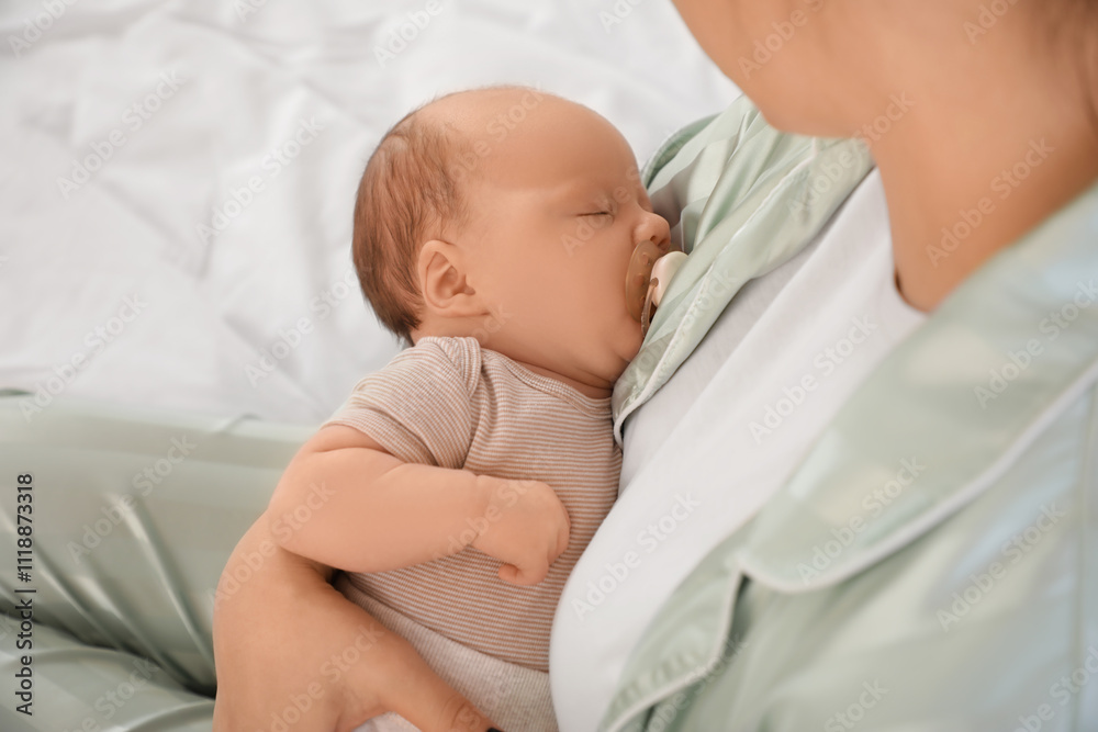 Mother holding her cute little sleeping baby on bed at home, closeup Mother holding her cute little sleeping baby on bed at home, closeup
