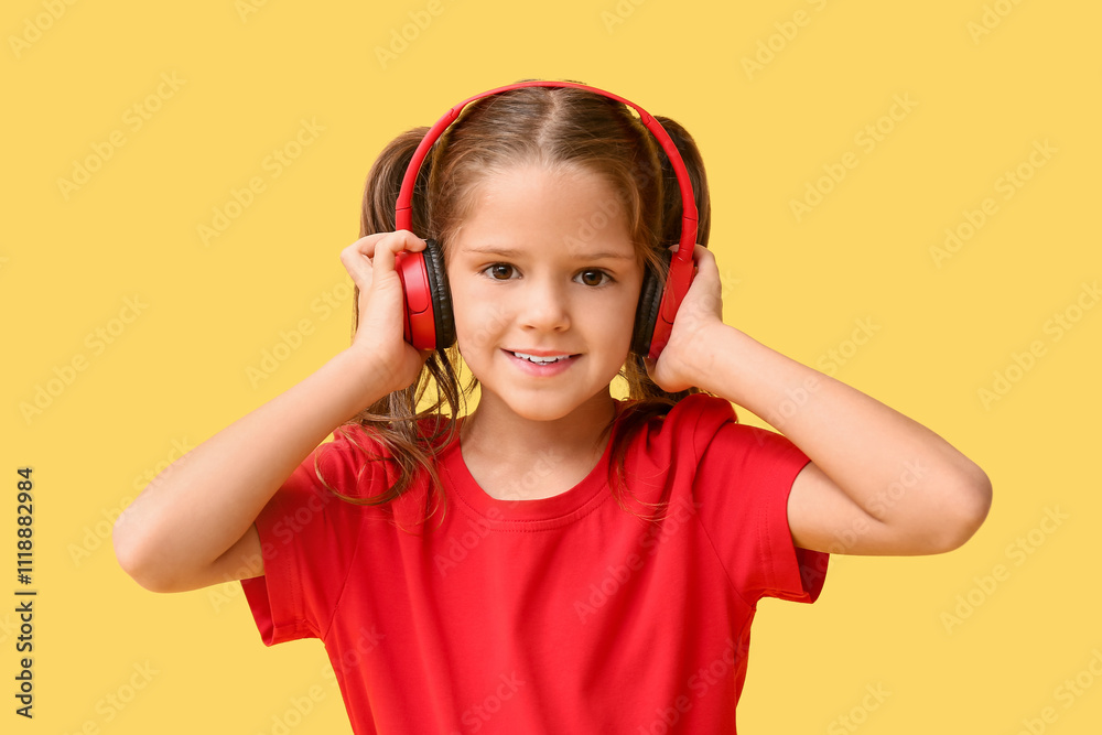Happy little girl in headphones on yellow background Happy little girl in headphones on yellow background