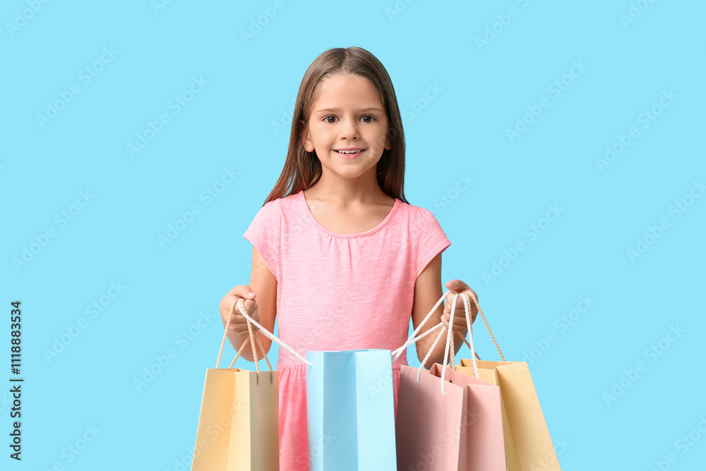 Happy little girl with shopping bags on blue background Happy little girl with shopping bags on blue background