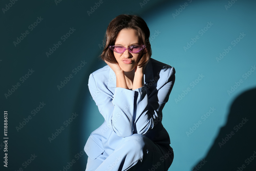 Beautiful young woman in stylish outfit on blue background Beautiful young woman in stylish outfit on blue background