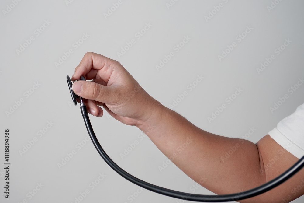Male person of a doctor nurse holding stethoscope, side view. Listening gesture. Over grey Male person of a doctor nurse holding stethoscope, side view. Listening gesture. Over grey