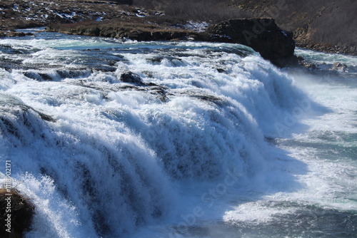 A powerful Icelandic waterfall flowing into a rugged canyon.