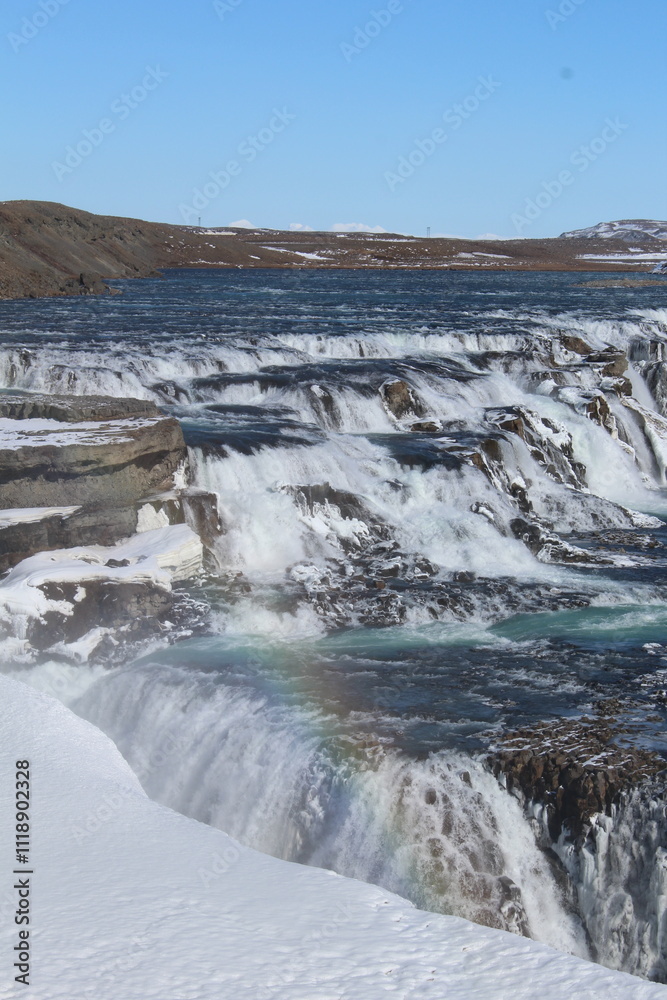 A powerful waterfall flowing through a frozen Icelandic canyon. A powerful waterfall flowing through a frozen Icelandic canyon.