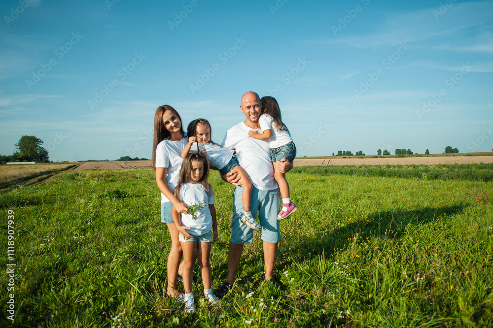 The family spends leisure time in the fresh air.Three sisters are playing in nature in the grass. The family spends leisure time in the fresh air.Three sisters are playing in nature in the grass.