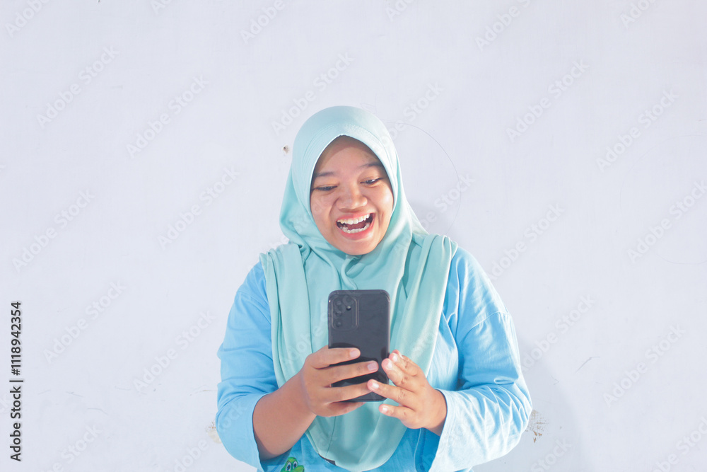 Fototapeta premium Happy Blue Hijab Woman Holding Smartphone on White Background