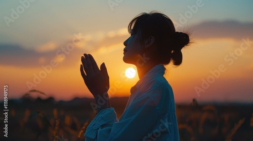 Woman raising hands in praise with faith and : Stock photo of Christian religion concept. Silhouette woman on sunrise background. Christian woman praying to God
