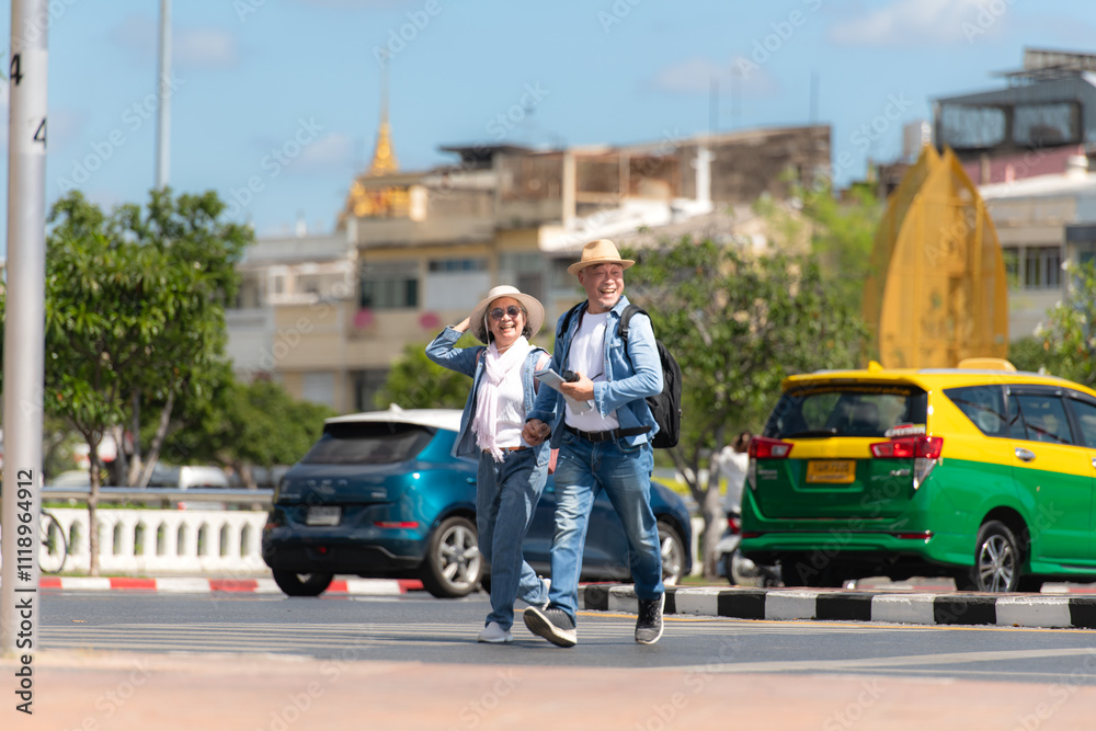 An elderly couple walks around the street in the old city of Bangkok, Thailand. An elderly couple walks around the street in the old city of Bangkok, Thailand.