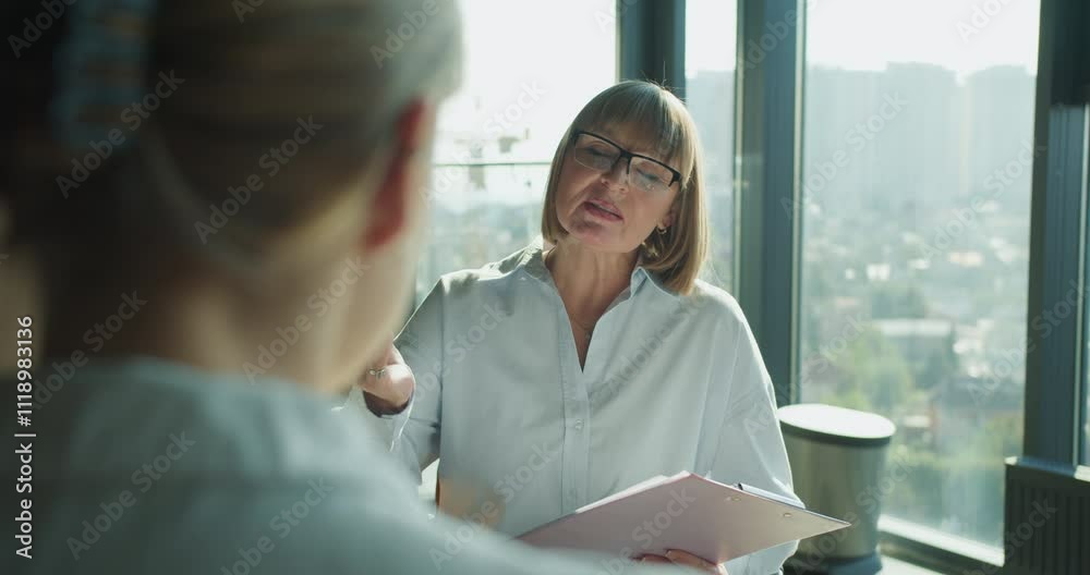 Focused business professional presenting and discussing important data during a team meeting in a modern office setting, highlighting leadership and collaboration in a corporate environment