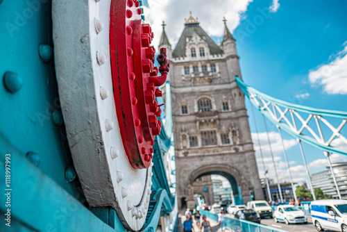 Close-Up of Tower Bridge in London on a Sunny Day Featuring Architectural Details and Traffic Flowing Beneath Iconic Structure, Highlighting the Vibrant Reds and Blues Against a Clear Sky