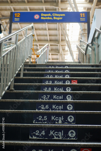 Train station stairs, leading to the platform with calories written on them