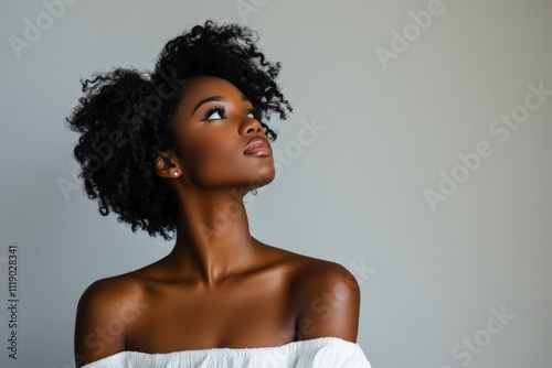 Elegant Portrait of a Young Woman with Natural Curly Hair Against a Neutral Background