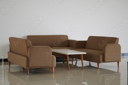 Three light brown three-seater sofas with a white wooden coffee table in a room with a white background photo