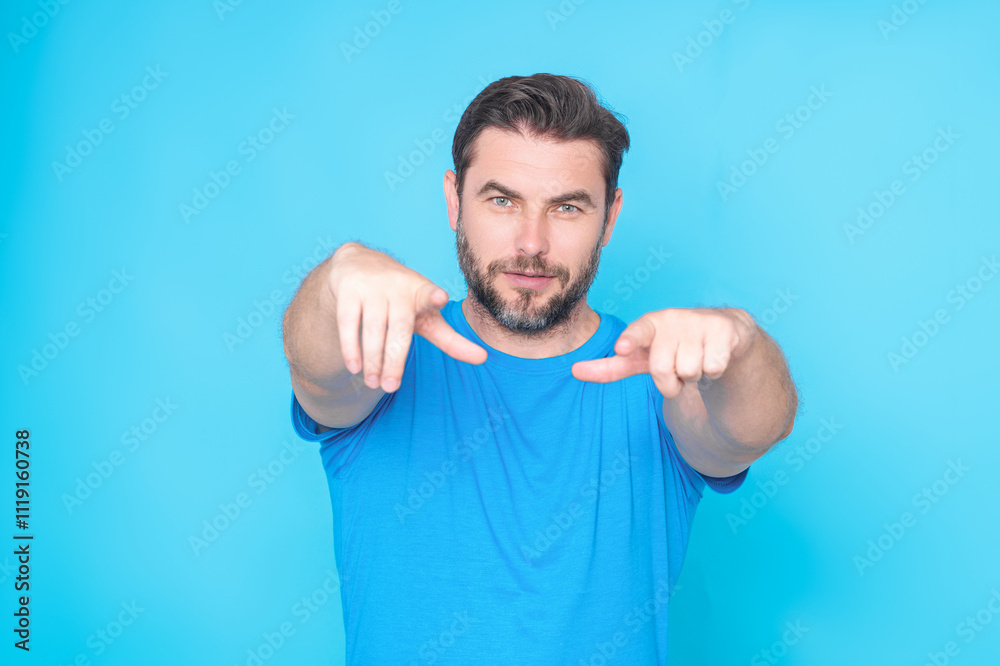 The point you. Happy handsome man pointing finger you away, isolated blue background. Excited man pointing a you great idea. Guy in blue t-shirt pointing you with his finger. The point you. Happy handsome man pointing finger you away, isolated blue background. Excited man pointing a you great idea. Guy in blue t-shirt pointing you with his finger.