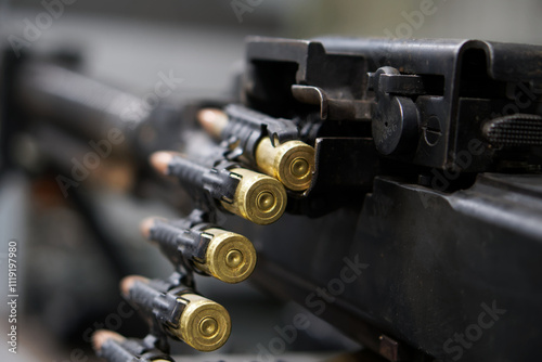 Close-up view of ammunition and firearm components in a military setting during daylight hours. Photo