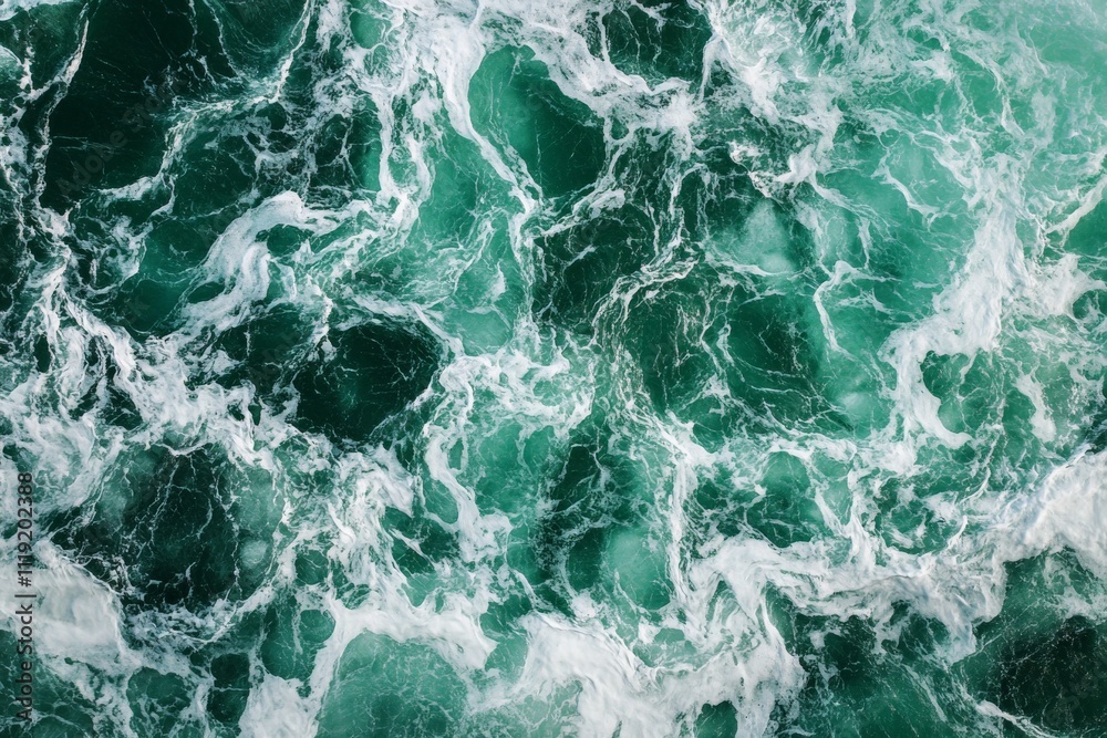 Fototapeta premium Waves crashing in emerald waters create a stunning pattern during daylight