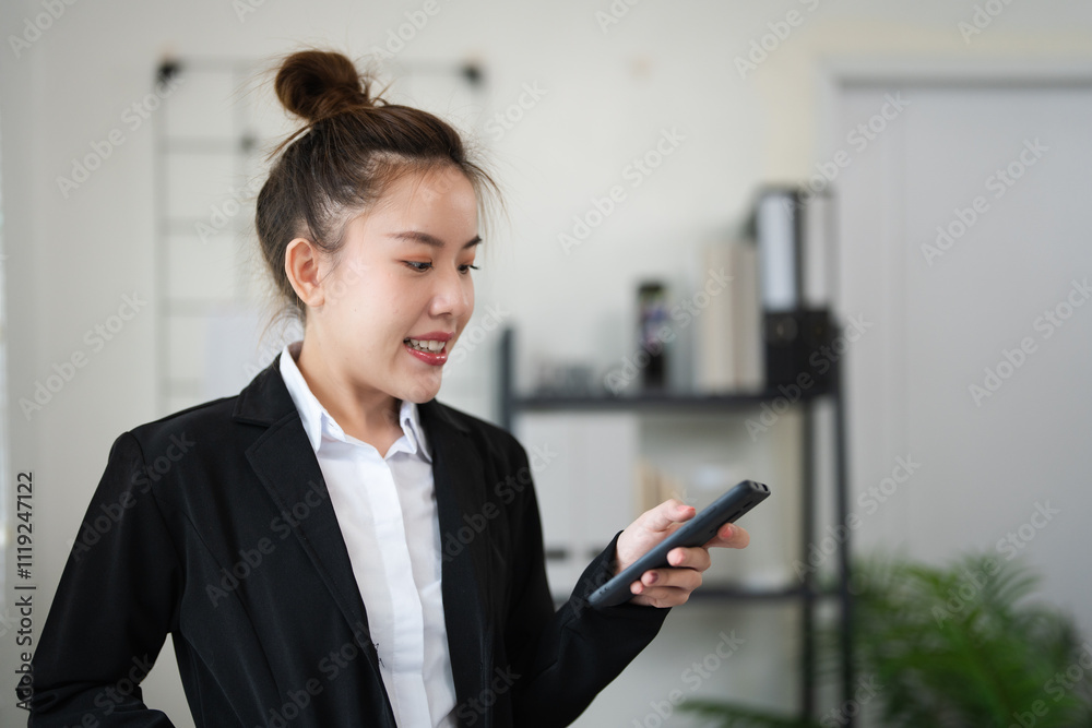 Attractive Asian businesswoman in office checking work schedule on smartphone. Attractive Asian businesswoman in office checking work schedule on smartphone.