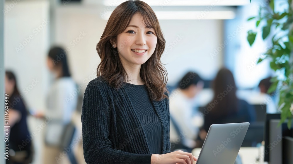 Smiling Japanese businesswoman standing in an office, holding her laptop. She is wearing casual clothes, and other people working behind her are blurred.,generated ai. Smiling Japanese businesswoman standing in an office, holding her laptop. She is wearing casual clothes, and other people working behind her are blurred.,generated ai.