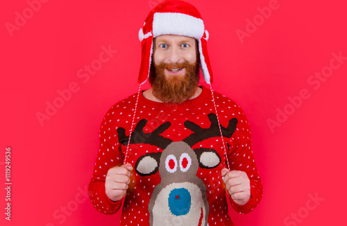 cheerful christmas man in earflap santa hat. merry christmas. bearded santa man on christmas holiday photo