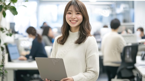 Free Download Smiling Japanese businesswoman standing in an office, holding her laptop. She is wearing casual clothes, and other people working behind her are blurred.,generated ai.	   - GFXLoad