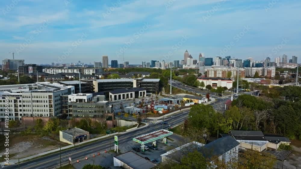 Modern houses with rusty gas station and skyline of Atlanta in backdrop. Aerial slow forward flight. Sunny day on foliage autumn day. Wide shot. Modern houses with rusty gas station and skyline of Atlanta in backdrop. Aerial slow forward flight. Sunny day on foliage autumn day. Wide shot.