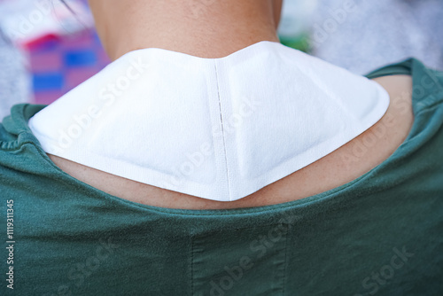 Image of a thermal plaster patch applied to the neck muscles to relieve neck pain. photo