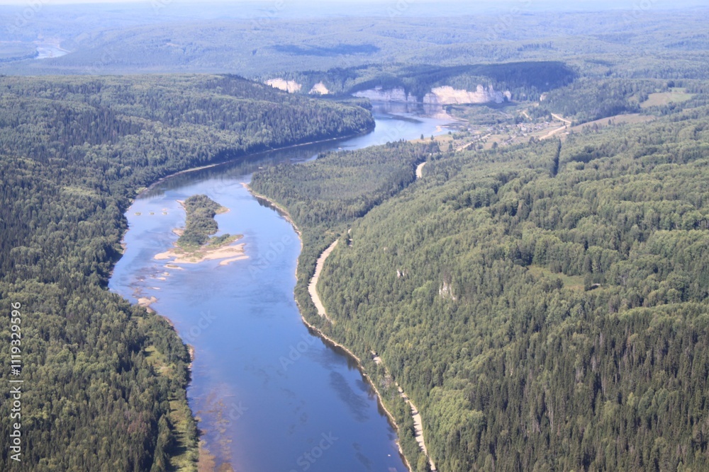 Obraz premium A river flows through a rural forested area