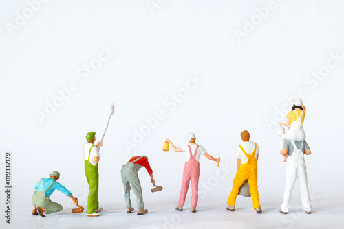 A group of colorful miniature figures dressed as painters in overalls on a clean white background, ideal for concepts like teamwork, renovation, or creative projects.