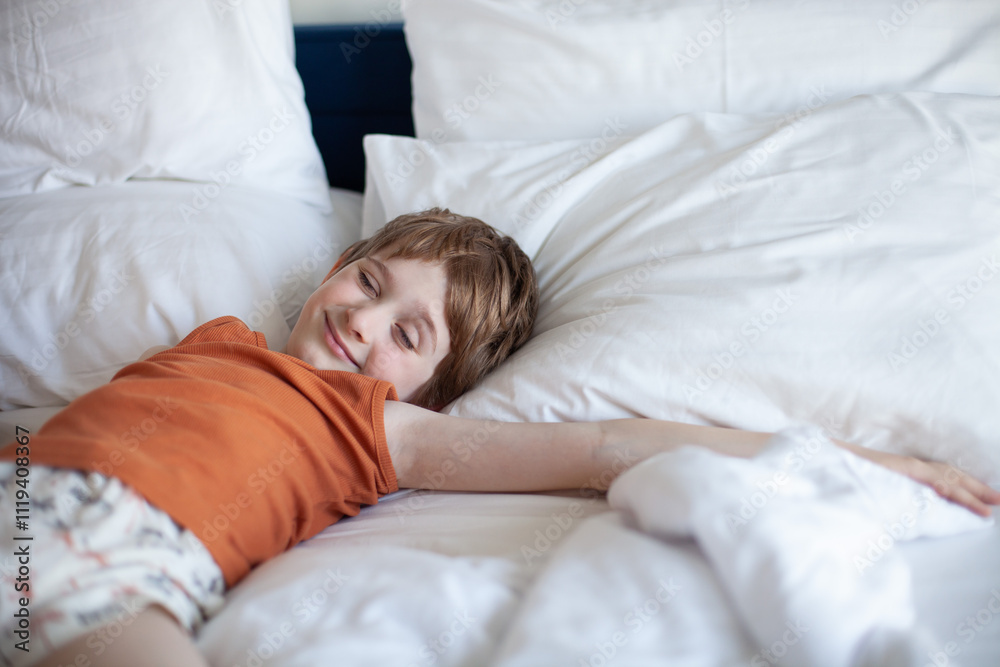 Little boy sleeping and smiling lying on a white pillows in bed. Child relaxing at home. Healthy sleep, good morning concept. Copy space. Little boy sleeping and smiling lying on a white pillows in bed. Child relaxing at home. Healthy sleep, good morning concept. Copy space.