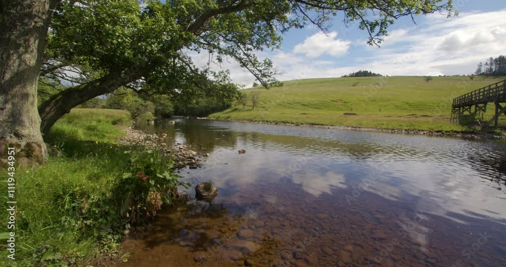 Looking across the river coquet next to a wooden footbridge, by holystone Northumbria Looking across the river coquet next to a wooden footbridge, by holystone Northumbria