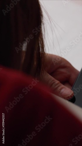 ベッドで寝そべってスマホを見ている女性