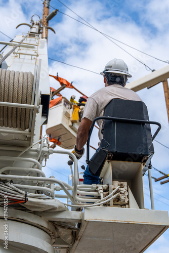Lineman signaling digger derrick operator near powerlines for safe operation